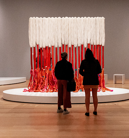 Sculpture with strands of pink and orange thread descending into a wild tangle