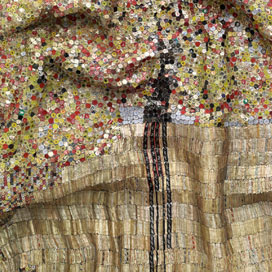 Detail of wavy scultpure made of small gold, red, and black bottle caps sewn together