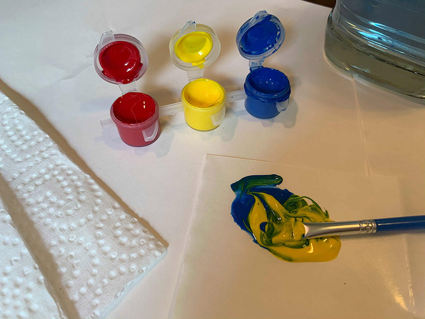 mixing yellow and blue paint with the paintbrush
