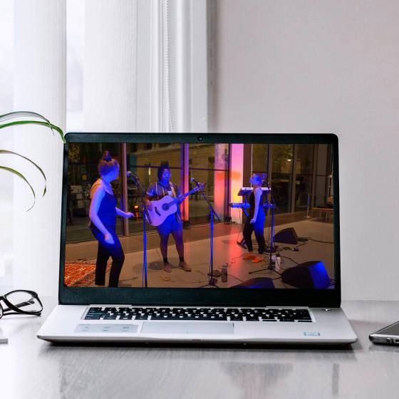 laptop playing video of musicians performing on stage for concert