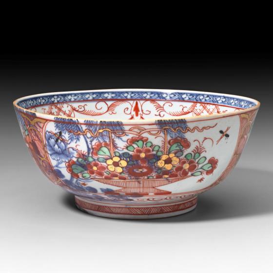 A blue-and-white punch bowl with elaborate enamel ornamentation on its surface.