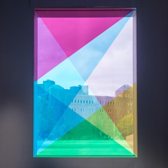 A window with various triangles of neon color overlayed across the pane.