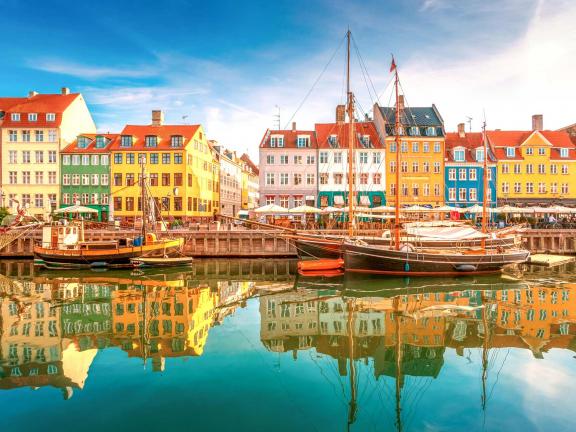 emfa travel Row of colorful buildings in Stockholm adjacent to water where a tall ship is anchored