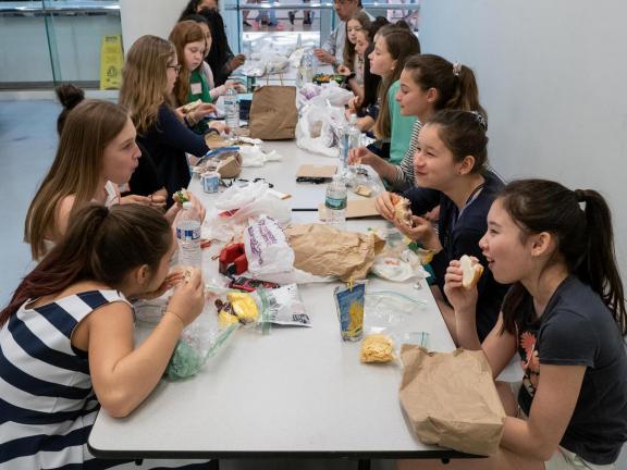 Students sitting at table eating lunch