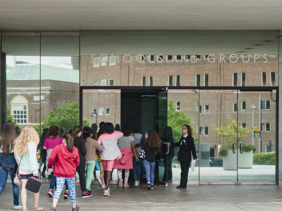 Line of kids in school group filing into Linde Family Wing entrance