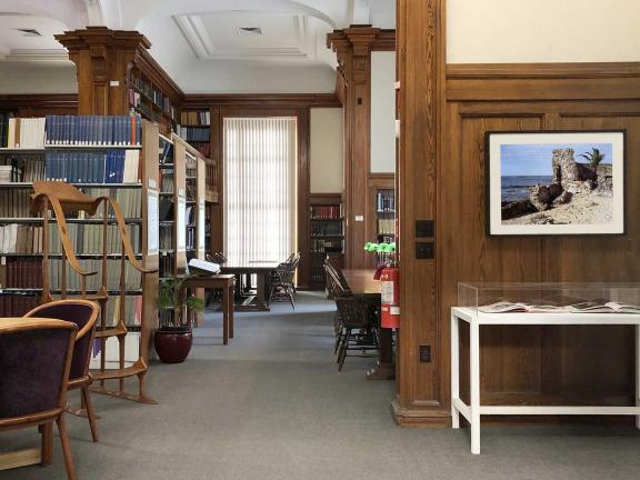 View of library stacks on the left and display case on the left