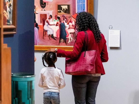 mother and small daughter in gallery looking at a painting