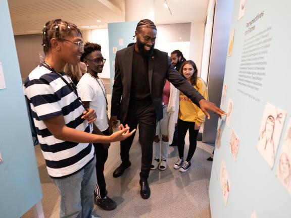 Boston Celtics star Jaylen Brown views "Portraits of Leadership: Responses to the Obama Portraits" with participants from the MFA's teen programs