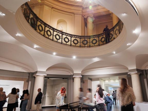View of rotunda looking up towards second level, with visitors strolling through