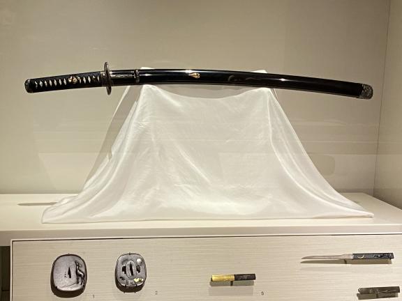 Japanese sword among other artworks in a display case