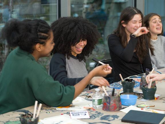 College visitors sitting at a table and creating art in the Museum's Shapiro Family Courtyard