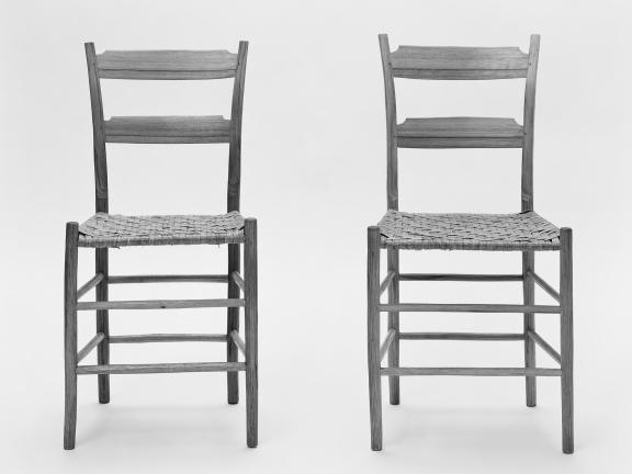 To small wooden chairs stand side by side.