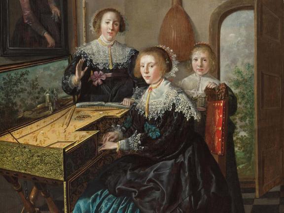 Three women gather around a keyboard in a dark interior.
