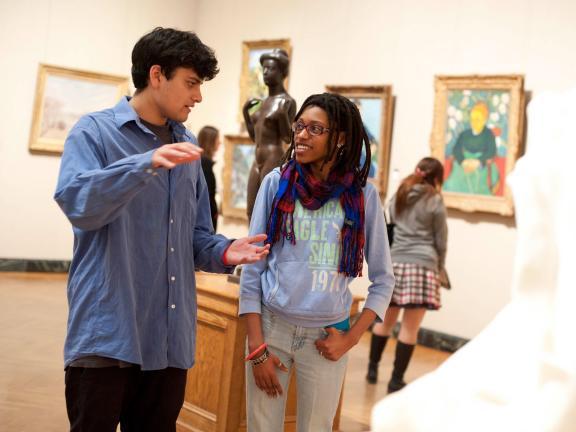 Two young visitos chatting in old Impressionism gallery