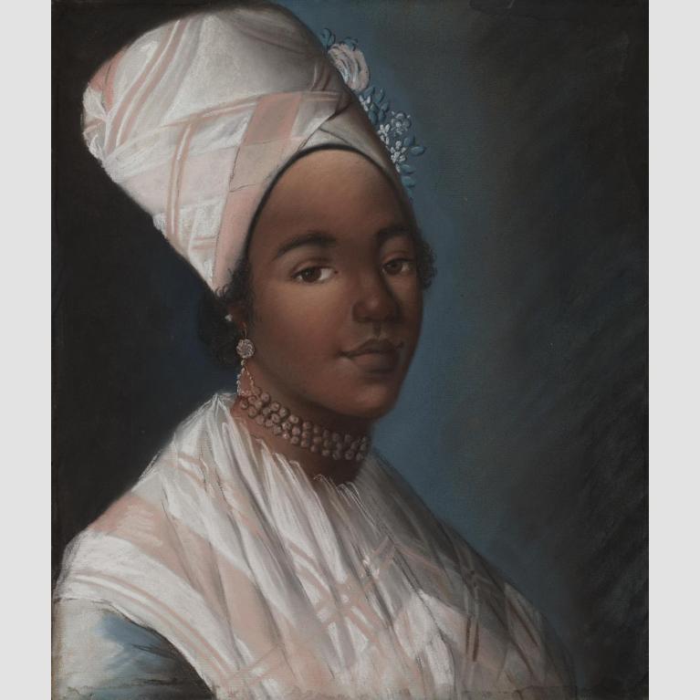 A woman in a pink and white shawl smiling.