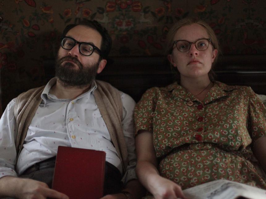 film still from Shirley, depicting couple sitting next to each other on bed