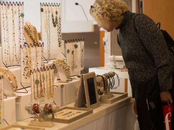 Woman shopping at table filled with jewelry