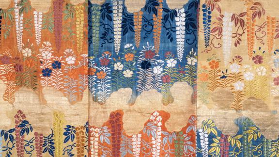 Close-up orange, blue, and yellow ornamentation of a robe.