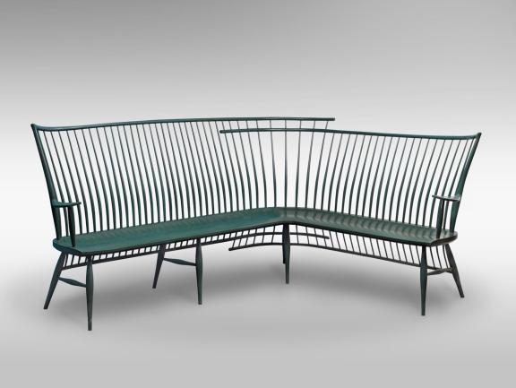 A dark green curved wooden bench