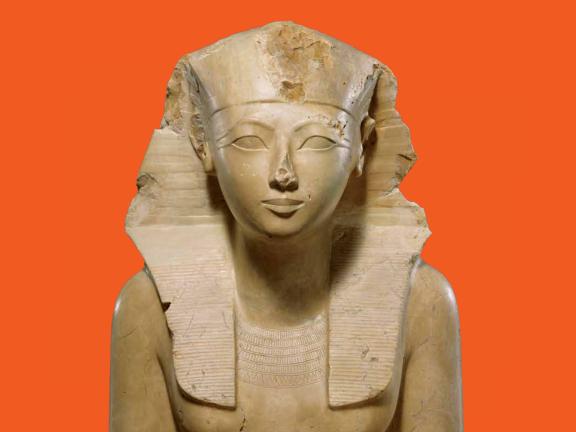 Detail of a painted limestone seated statue of Hatshepsut wearing a headcloth and kilt