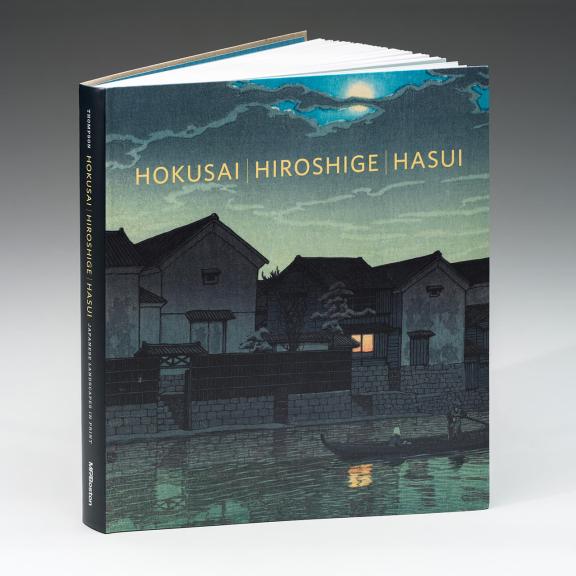 Image of book cover Hokusai, Hiroshige, Hasui. The cover features a print of houses along a river at dusk. A boat is on the river and the moon is visible through the clouds. A window in one house is lit and reflects on the water.
