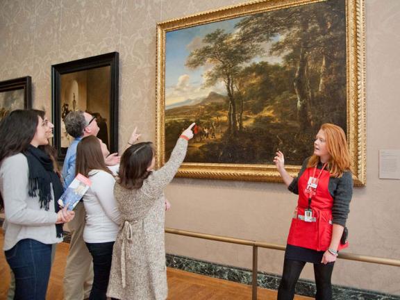 Visitors in tour group pointing at painting, with MFA Ambassador standing in front of painting