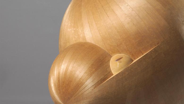 A bulbous abstract figure that is a shimmering light brown.
