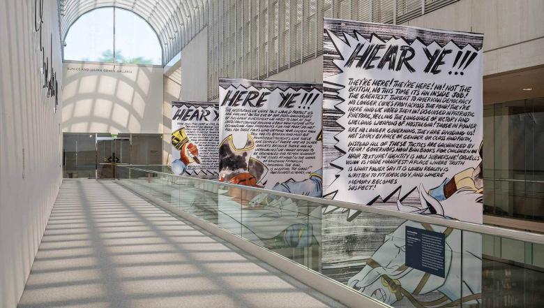A sunlit hallway with large banners hanging from the rafters.